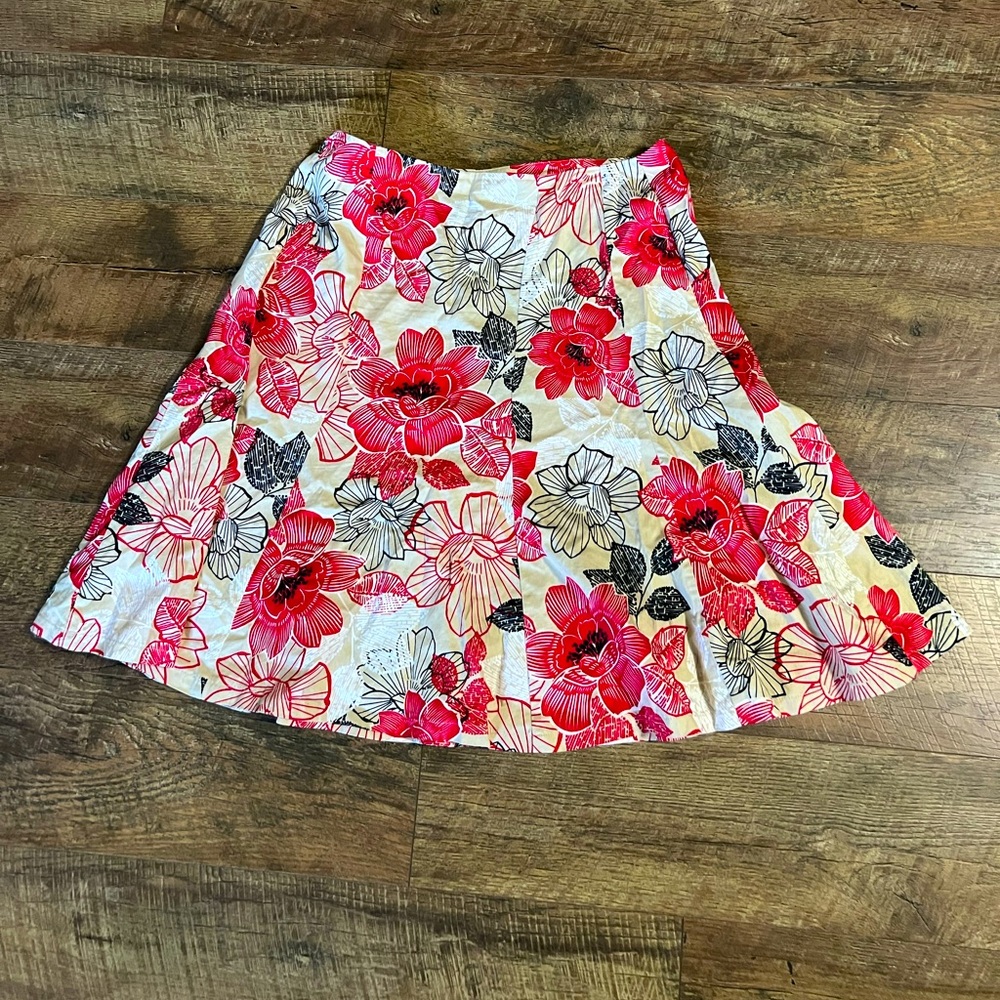 a cute, floral patterned, cream colored, knee length skirt